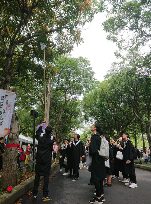 畢業生與居民都在打芒果的活動中同樂